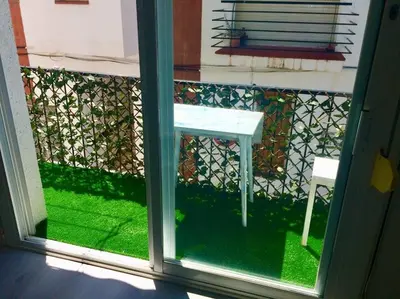 a window with a white table on a balcony at SITGES Apartment PALLARÉS in Sitges