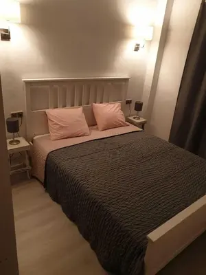 a bedroom with a large bed with two pink pillows at SITGES Apartment PALLARÉS in Sitges