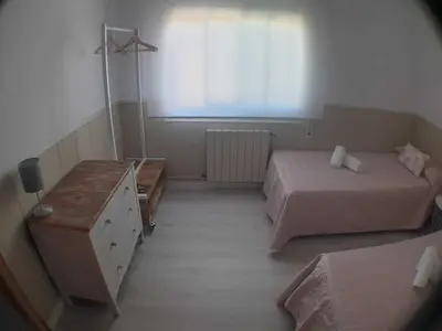 a bedroom with two beds and a dresser and a window at SITGES Apartment PALLARÉS in Sitges