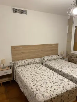 a bedroom with two beds and a headboard at Masia Can Llonch in Palau-Solità i Plegamans