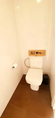 a bathroom with a toilet with a sign on it at Attic360Views in Barcelona