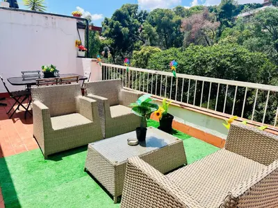 a patio with wicker chairs and a table on a balcony at Attic360Views in Barcelona