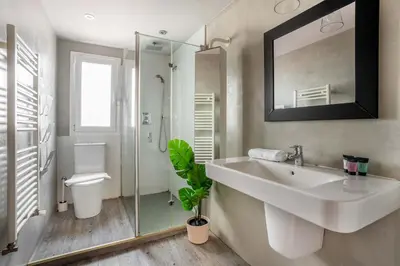 a bedroom with two beds and a mirror at The Collection Barcelona - Amazing 3 bedroom penthouse in Plaza España in Barcelona