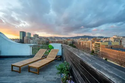 two chairs sitting on top of a balcony with a city at The Collection Barcelona - Amazing 3 bedroom penthouse in Plaza España in Barcelona