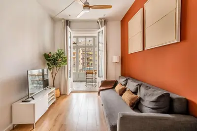 a living room with a couch and a television at The Collection Barcelona - Stylish and centric 2-bedroom apartment with Terrace in Eixample in Barcelona