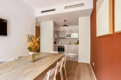 a kitchen and dining room with a wooden table and chairs at The Collection Barcelona - Stylish and centric 2-bedroom apartment with Terrace in Eixample in Barcelona