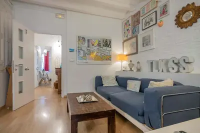 a living room with a blue couch and a table at The Collection Barcelona - Exclusive 2 bedroom apartment in the city center in Barcelona