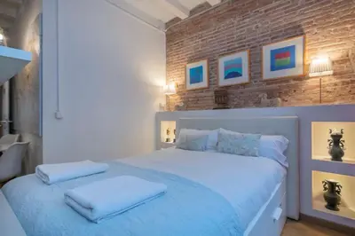 a bedroom with a white bed with two towels on it at The Collection Barcelona - Exclusive 2 bedroom apartment in the city center in Barcelona