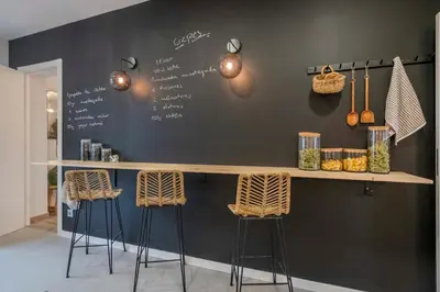a bar with two stools and a wall with writing on it at The Collection Barcelona - Luxury 4-bedrooms in Rambla de Catalunya in Barcelona