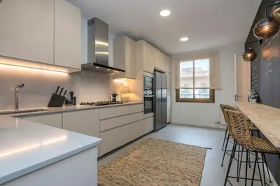 a kitchen with white cabinets and a table with chairs at The Collection Barcelona - Luxury 4-bedrooms in Rambla de Catalunya in Barcelona