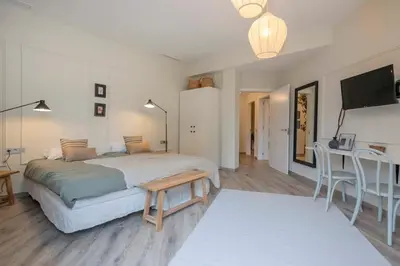 a bedroom with a bed and a table and a television at The Collection Barcelona - Luxury 4-bedrooms in Rambla de Catalunya in Barcelona