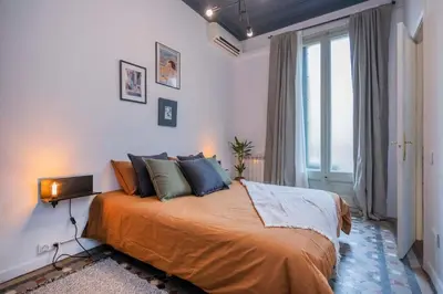 a bedroom with a large bed and a window at The Collection Barcelona - Elegant 4 bedrooms 3 bathrooms Catalan home in Barcelona
