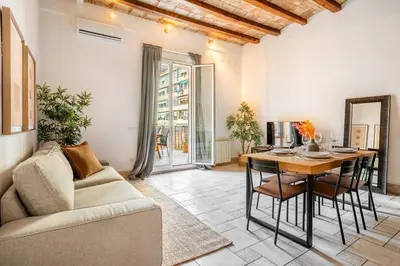 a living room with a table and a couch at The Collection Barcelona - Historic apartment with private terrace in Example in Barcelona