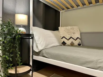 a bed with a pillow and a plant in a room at The Collection Barcelona - Poble Sec - Modern & comfy 3 bedrooms in Barcelona