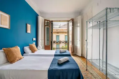 a bedroom with two beds and a blue wall at The Collection Barcelona - Exclusive Luxe Design - Large Tranquil Penthouse in Barcelona