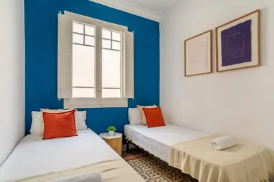 two beds in a room with blue walls and a window at The Collection Barcelona - Exclusive Luxe Design - Large Tranquil Penthouse in Barcelona