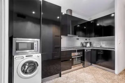 a kitchen with a washing machine and a microwave at The Collection Barcelona - Ronda Sant Pere in Barcelona