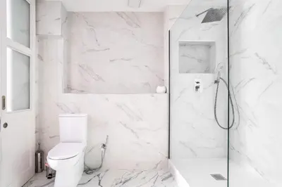 a white bathroom with a shower and a toilet at The Collection Barcelona - Ronda Sant Pere in Barcelona