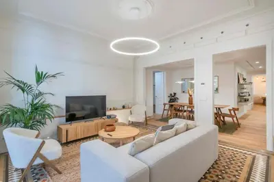 a living room with a white couch and a tv at The Collection Barcelona - Exclusive Paseo de Gracia 5BD 5BTH with terrace in Barcelona