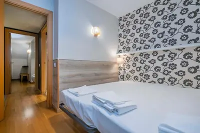 a bedroom with a white bed with a black and white wall at The Collection Barcelona - Bright and modern Duplex with terrace in Eixample district P1 in Barcelona
