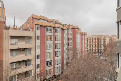 a white chair on a balcony with buildings at The Collection Barcelona - 2 bedroom Duplex apartment with balcony 4-3 in Barcelona