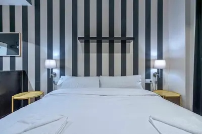 a quotationatory logo with a magnifying glass at The Collection Barcelona - 2 bedroom with balcony in Eixample 4-2 in Barcelona