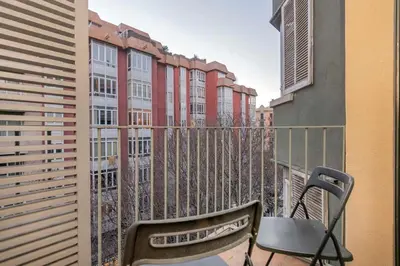 a living room with a couch and a desk with a tv at The Collection Barcelona - 2 bedroom with balcony in Eixample 4-2 in Barcelona