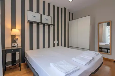 a bedroom with a bed with a striped wall at The Collection Barcelona - Modern and bright apartment in Eixample 5-1 in Barcelona