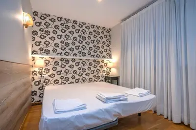 a bedroom with a white bed with a black and white wall at The Collection Barcelona - Bright and modern Duplex with terrace in Eixample district P2 in Barcelona