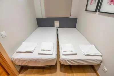 a white bedroom with a large bed and a window at The Collection Barcelona - 2 bedroom with balcony in Eixample 1-1 in Barcelona