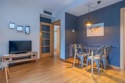 a living room with a table and chairs and a tv at The Collection Barcelona - Modern and bright apartment in Eixample 2-1 in Barcelona