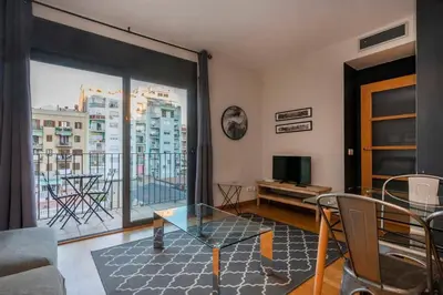 a living room with a glass table and a large window at The Collection Barcelona - Modern and bright apartment in Eixample 3-1 in Barcelona
