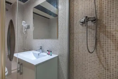 a bathroom with a sink and a shower with a mirror at The Collection Barcelona - 2 bedroom with balcony in Eixample 3-2 in Barcelona