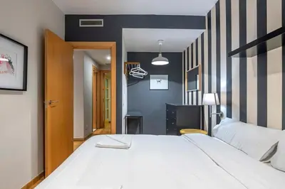 a bedroom with a large white bed and a black and white wall at The Collection Barcelona - 2 bedroom with balcony in Eixample 3-2 in Barcelona