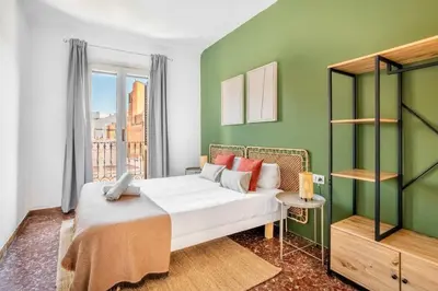 a bedroom with a white bed and a green wall at The Collection Barcelona - Big apartment for 15 in the heart of Eixample in Barcelona