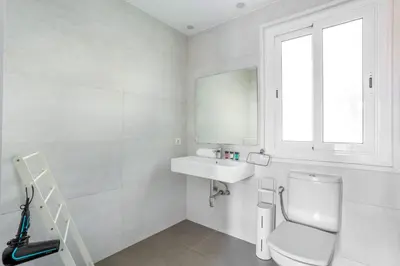 a white bathroom with a toilet and a sink at The Collection Barcelona - Big apartment for 15 in the heart of Eixample in Barcelona