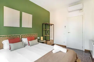 a bedroom with a white bed and a green wall at The Collection Barcelona - Big apartment for 15 in the heart of Eixample in Barcelona