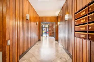 a hallway with wood paneled walls and a tile floor at The Collection Barcelona - Big apartment for 15 in the heart of Eixample in Barcelona