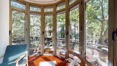 a large room with large windows and a blue chair at The Collection Barcelona - Modern and bright three-bedroom in Eixample in Barcelona