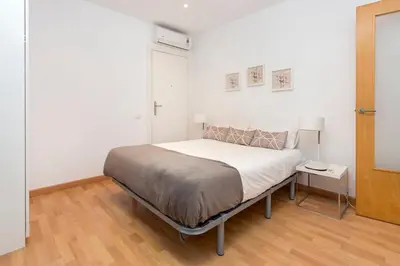 a white bedroom with a bed and a table at The Collection Barcelona - Spacious and Elegant 4 Bedroom with Private Terrace in Barcelona