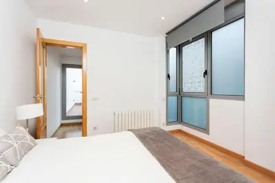 a bedroom with a white bed and a large window at The Collection Barcelona - Spacious and Elegant 4 Bedroom with Private Terrace in Barcelona