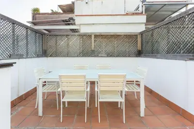 a white table and chairs on a patio at The Collection Barcelona - Spacious and Elegant 4 Bedroom with Private Terrace in Barcelona