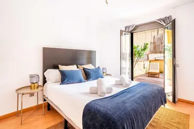 a bedroom with a large bed with blue pillows at The Collection Barcelona - Pl Universitat Comfortable 3BD with private patio in Barcelona