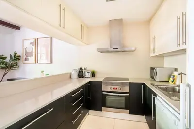 a kitchen with black and white cabinets and a sink at The Collection Barcelona - Pl Universitat Comfortable 3BD with private patio in Barcelona