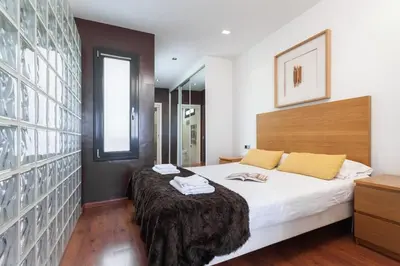 a bedroom with a large bed and a mirror at The Collection Barcelona - Sunny Atico with Terrace in Pl Universitat! in Barcelona