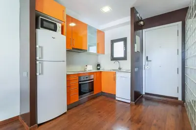 a kitchen with orange cabinets and a white refrigerator at The Collection Barcelona - Sunny Atico with Terrace in Pl Universitat! in Barcelona