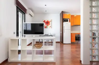 a kitchen with a white table with a tv on it at The Collection Barcelona - Sunny Atico with Terrace in Pl Universitat! in Barcelona