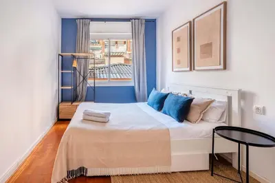 a bedroom with a large bed with blue walls at The Collection Barcelona - Next to Sagrada Familia 4-bedroom Apartment in Barcelona