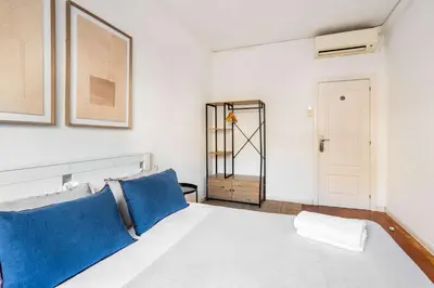 a bedroom with a white bed with blue pillows at The Collection Barcelona - Next to Sagrada Familia 4-bedroom Apartment in Barcelona