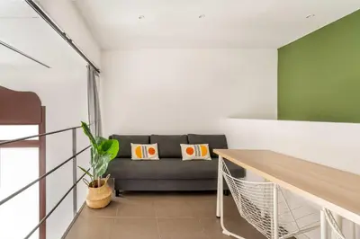 a living room with a couch and a table at The Collection Barcelona - Modern and bright 4BD triplex in Paralel! in Barcelona
